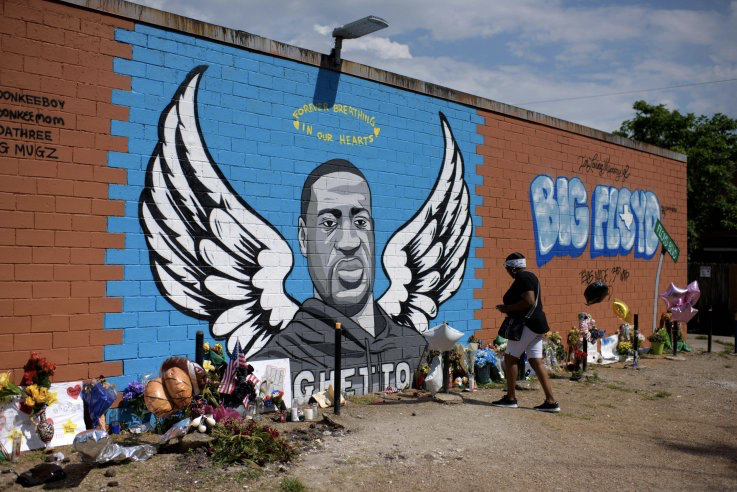 Visitors pay their respects to George Floyd in front of a mural in Houston, Texas on Monday, June 8, 2020